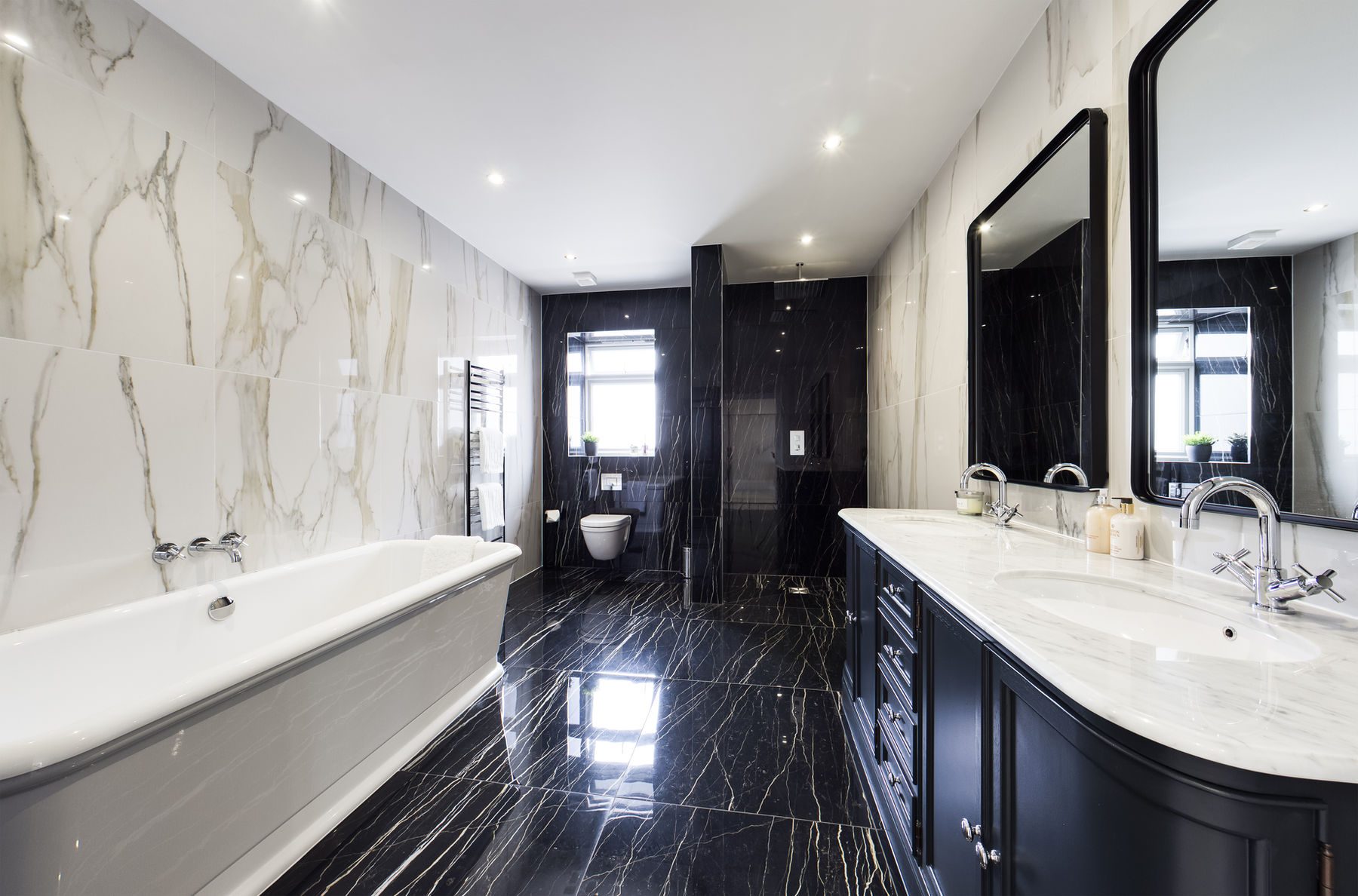 Marble bathroom with a freestanding bath and black floor